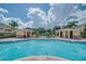 Clear blue community pool between two pool houses on a partly cloudy day at 5377 Quarry Rock Rd, Lakeland, FL 33809