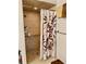 Accessible shower stall with brown tile, a leaf patterned curtain, and grab bars at 5422 Oakway Dr, Lakeland, FL 33805