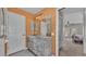 Bathroom with a marble countertop vanity, framed mirror and adjacent doorway leading to a bedroom with natural light at 5435 Myrtle Hill W Dr, Lakeland, FL 33811