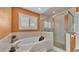 Bright bathroom featuring a soaking tub, an enclosed glass shower, and a large window providing natural light at 5435 Myrtle Hill W Dr, Lakeland, FL 33811