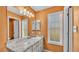 Bathroom with a marble countertop vanity, large mirror and a window providing natural light at 5435 Myrtle Hill W Dr, Lakeland, FL 33811