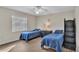 Bright bedroom features two twin beds with blue bedding and a black dresser with a sign that says 'Little Personal Cave' at 5435 Myrtle Hill W Dr, Lakeland, FL 33811