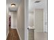 Hallway featuring wood and tile flooring leading to a bathroom with marble countertop vanity at 5435 Myrtle Hill W Dr, Lakeland, FL 33811