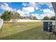 Grassy backyard with a full, white fence. There is a central air unit visible on the side of the house at 554 Lorient Dr, Eagle Lake, FL 33839