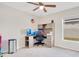 Bright bedroom featuring an expansive desk and a ceiling fan for added comfort at 554 Lorient Dr, Eagle Lake, FL 33839