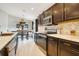 Well-lit kitchen featuring stainless steel appliances, dark wood cabinets, and a cozy breakfast nook by the window at 554 Lorient Dr, Eagle Lake, FL 33839