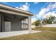 View of the screened porch that has a ceiling fan and overlooks the backyard and the white fence surrounding the property at 554 Lorient Dr, Eagle Lake, FL 33839