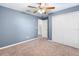 Bedroom with carpet, white closet doors, ceiling fan, and blue walls at 560 Hatchwood Dr, Haines City, FL 33844