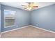 Bright bedroom with carpet, ceiling fan, large window, and blue walls at 560 Hatchwood Dr, Haines City, FL 33844