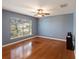 Bedroom with hardwood floors, blue walls, ceiling fan, and a large window at 560 Hatchwood Dr, Haines City, FL 33844