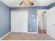 Bedroom features carpet flooring, blue walls, and a double door closet at 560 Hatchwood Dr, Haines City, FL 33844