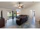 Spacious living room with tile floors, vaulted ceiling, sliding glass doors, and leather furniture at 560 Hatchwood Dr, Haines City, FL 33844