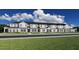 New construction townhomes featuring multiple units, complemented by well-manicured front yards and ample parking at 5747 Freshwater Canyon Dr, St Cloud, FL 34771