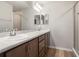 Bright bathroom featuring dual sinks, marble countertops, wood floors, and a glass door shower at 5751 Freshwater Canyon Dr, St Cloud, FL 34771