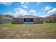 Back exterior view of home featuring screened patio and large grassy lawn at 6339 Alamanda Hills Dr, Lakeland, FL 33813