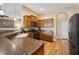 Kitchen with a view of the living room, featuring stainless steel appliances and wood cabinets at 6339 Alamanda Hills Dr, Lakeland, FL 33813