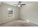 Cozy bedroom with plush carpet, ceiling fan, and ample natural light from a window at 645 Sarner Pass Way, Winter Haven, FL 33881