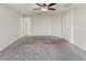 This carpeted bedroom features neutral walls, a ceiling fan, and doors to a closet and the hallway at 645 Sarner Pass Way, Winter Haven, FL 33881