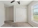 This cozy bedroom features a ceiling fan, neutral walls and carpet, a window and a closet with paneled doors at 645 Sarner Pass Way, Winter Haven, FL 33881