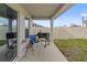 A covered patio with grill and chairs is ready for backyard entertaining at 645 Sarner Pass Way, Winter Haven, FL 33881