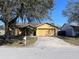 Inviting single-story home with an attached two-car garage, mature trees, and green lawn at 6528 Shepherd Oaks Pass, Lakeland, FL 33811