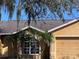 Close up view of the home's facade with palm trees lining the front windows at 6528 Shepherd Oaks Pass, Lakeland, FL 33811