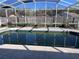 A partially screened-in pool deck with lounge chairs and a shaded area at 6528 Shepherd Oaks Pass, Lakeland, FL 33811