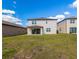 View of the house from the backyard, showcasing sliding glass doors and ample lawn space at 685 Meadow Pointe Dr, Haines City, FL 33844