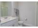 Well-lit bathroom features a vanity with sink, toilet, towel rack, and a glass-enclosed shower stall at 685 Meadow Pointe Dr, Haines City, FL 33844