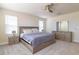 Stylish bedroom featuring neutral decor, plush carpeting, a ceiling fan, and plenty of natural light at 685 Meadow Pointe Dr, Haines City, FL 33844