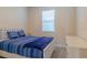 Comfortable bedroom showcasing a bed with blue striped bedding, a bright window and a white dresser at 685 Meadow Pointe Dr, Haines City, FL 33844