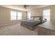 Relaxing bedroom with neutral tones, soft carpeting, a ceiling fan, and ample natural light from two windows at 685 Meadow Pointe Dr, Haines City, FL 33844