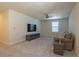 Large bonus room featuring a television, comfortable seating, ceiling fan and neutral carpet at 685 Meadow Pointe Dr, Haines City, FL 33844