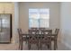 Bright dining area featuring a modern table set, stainless steel refrigerator, and natural light from the window at 685 Meadow Pointe Dr, Haines City, FL 33844