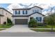 Two-story home with a two-car garage, dark shutters, and a well-manicured lawn at 685 Meadow Pointe Dr, Haines City, FL 33844