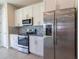 Modern kitchen with stainless steel appliances, white cabinets, and tile backsplash at 685 Meadow Pointe Dr, Haines City, FL 33844