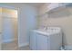 Well-equipped laundry room with a modern washer and dryer, wire shelving, and stylish tile flooring at 685 Meadow Pointe Dr, Haines City, FL 33844