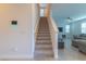 Carpeted staircase leading to the second floor, with modern white railings and a wall-mounted smart home device at 685 Meadow Pointe Dr, Haines City, FL 33844