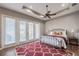 Primary bedroom boasting wood-look tile floors, ceiling fan, and French doors to the backyard at 7104 Lake Eaglebrooke Way, Lakeland, FL 33813