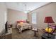 Bedroom features neutral paint and carpet, ceiling fan, chair and side table with lamp at 7104 Lake Eaglebrooke Way, Lakeland, FL 33813