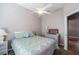 Bedroom features neutral paint and carpet, ceiling fan, large window, dresser and side table at 7104 Lake Eaglebrooke Way, Lakeland, FL 33813