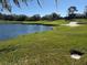 Scenic view of a golf course with lush green grass, a tranquil lake, and scattered trees at 7104 Lake Eaglebrooke Way, Lakeland, FL 33813