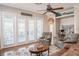 Bright living room featuring a ceiling fan, three sets of french doors, and wood-look tile floors at 7104 Lake Eaglebrooke Way, Lakeland, FL 33813