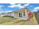 Rear view of home featuring covered patio, small yard, pond and black fence at 7187 Cruz Ct, Lakeland, FL 33813