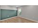 Neutral bedroom featuring a bright window, light wood floors, and soft green accent wall at 7187 Cruz Ct, Lakeland, FL 33813