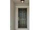 Classic six-panel front door framed by white trim and a modern light fixture at 7187 Cruz Ct, Lakeland, FL 33813