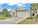 Charming single-story home featuring a two-car garage, well-manicured lawn, and palm tree landscaping at 7187 Cruz Ct, Lakeland, FL 33813