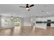 Open living room area showing light wood floors, pendant lighting, and view into the kitchen at 7187 Cruz Ct, Lakeland, FL 33813