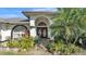 Close up of the front entrance, showcasing a tile entryway and lush landscaping at 7321 Gunstock Dr, Lakeland, FL 33809