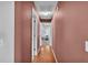 Long hallway with hardwood floors and neutral colored walls leading to various rooms in the home at 7321 Gunstock Dr, Lakeland, FL 33809